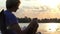 Bright Man Drinks Coffee in a Folding Chair With His Notepad at Sunset in Slo-Mo