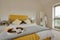 Bright modern furnished bedroom in yellow and white with teatray