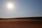 Bright morning sun on a hot and dry rippled desert landscape