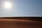 Bright morning sun on a hot and dry rippled desert landscape