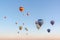 Bright multi-colored hot air balloons flying in sunsrise sky