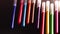 Bright multicolored markers rolling on black background. Art, pain, write, stationery, felt tip