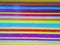 Bright multicolored painted metal roller blinds background. Closed corrugated shutters door rainbow texture