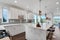 Bright and neutral kitchen with a large marble waterfall island