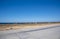 Bright orange bungalows stand in the steppe next to the sea. A Sunny summer day with a cloudless sky