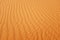 Bright orange color desert sand wave patterns for a warm summer background.