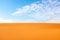 Bright orange color rippled desert sand and clear blue sky for a warm hot summer background