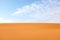 Bright orange desert sand ripples and clear blue sky. Summer background