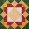 Bright orange-green geometric patchwork block from pieces of fabrics, detail of quilt