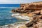 Bright orange karst sandy coastal cliffs blurred by blue waters of Mediterranean sea, Ibiza, Balearic Islands, Spain