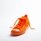 Bright Orange Knit Sneaker Still Life Photo In White Space