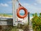 Bright orange life bouy hanging on side of beach access on tropical island