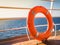 Bright, orange lifebuoy on the top deck of the cruise liner