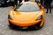 Bright orange McLaren sports race car in street