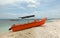 Bright orange panga / fishing boat on coral beach in Sri Lanka