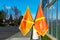 Bright orange pedestrian crossing flags at a crosswalk in residential neighborhood near school