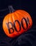 Bright orange pumpkin with Boo! written in black