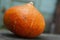 Bright orange pumpkin on a wooden table. Autumn festive vegetable. Vitamins and health from nature. Close-up