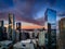 Bright orange and purple sunset with tall skyscrapers in the foreground and the San Francisco Bay with the Bay Bridge