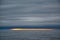 Bright orange yellow colors of sunset in small strip on horizont over dark sea with dark cloudy sky, Antarctic Ocean, Antarctica