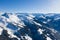 Bright panorama of mountain ranges with snow and ice on the tops against the blue sky in winter and dense forests