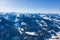 Bright panorama of mountain ranges with snow and ice on the tops against the blue sky in winter and dense forests