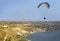 Bright paraglider, paragliding, sport, flying over a river, soar in the sky, aerial view, rocky coast