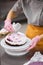 A bright pastry chef girl is engaged in the preparation of a cake