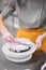 A bright pastry chef girl is engaged in the preparation of a cake