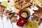 A bright photo with an enameled cup of hot tea, an apple pie, autumn leaves, cinnamon sticks and red knitted scarf on white