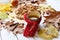 A bright photo with an enameled cup of hot tea, an apple pie, autumn leaves, cinnamon sticks and red knitted scarf on white