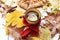 A bright photo with an enameled cup of hot tea, an apple pie, autumn leaves, cinnamon sticks and red knitted scarf on white