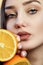 Bright picture of beautiful woman with orange halves, girl face with languid look, fashion model, concept fruits and healthy food