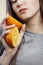 Bright picture of beautiful woman with orange halves, girl face with languid look, fashion model, concept fruits and healthy food