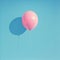 Bright pink balloon stands out against bold blue background