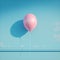 Bright pink balloon stands out against bold blue background