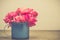 Bright pink carnations flower in blue cup on table . Vintge image style
