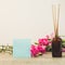 Bright pink carnations flower in the japanese glass vase on table and blank blue card . Vintge image style