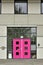 Bright pink door in a gray building