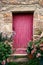 Bright Pink Paint Wood Door on Old Stone House
