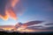 Bright pink and shades of intensity of sunset colored sky over wide landscape below