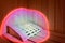 Bright pink spotlight beam illuminates wooden sauna bench