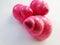 Bright pink vibrant twisted glossy shiny snail shells composition lens isolated on a white background.