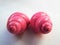 Bright pink vibrant twisted glossy shiny snail shells composition lens isolated on a white background.