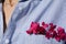Bright pink wildflowers in a pocket of a cotton women& x27;s shirt