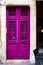 Bright purple old rustic vintage french door. European architecture details. unique amazing doorway. fresh violet paint