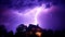 Bright purple sky illuminates dark landscape, majestic thunderstorm brewing generated by AI