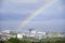 Bright rainbow high in sky over the sea during dark storm