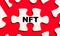 On a bright red background, white puzzles. In one of the pieces of the puzzle, the text NFT Non Fungible Token