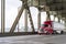 Bright red big rig semi truck transporting cargo in refrigerator semi trailer moving on the two levels bridge across Willamette